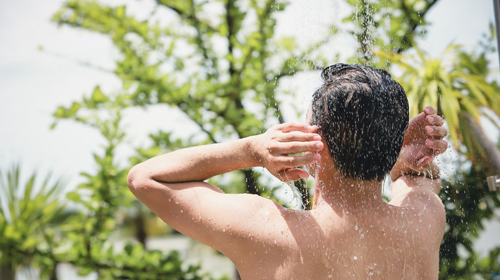 Mann duscht in einem tropischen Garten (Quelle: Colourbox)