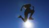 Sportliche Frau springt in den blauen Himmel (Quelle: imago / Westend61)