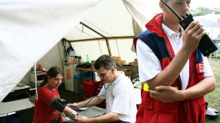 Sanitäter des Arbeiter Samariterbundes versorgt eine Jugendliche (Quelle: imago/Sabine Gudath)