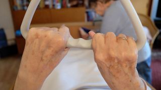 Alte Hände halten Griff in Pflegebett (Bild: imago/Martin Wagner)