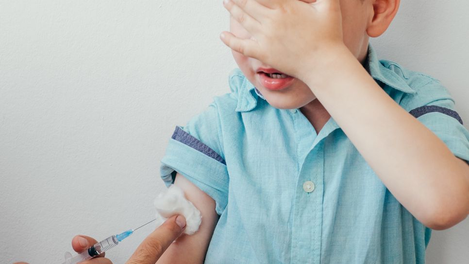 Kleiner Junge verdeckt mit Hand Augen, um Impfspritze nicht zu sehen (Bild: Colourbox)
