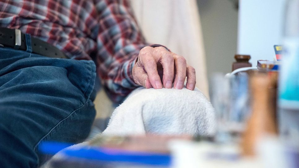 Hand eines älteren Mannes liegt auf Sessellehne (Bild: imago images/epd)