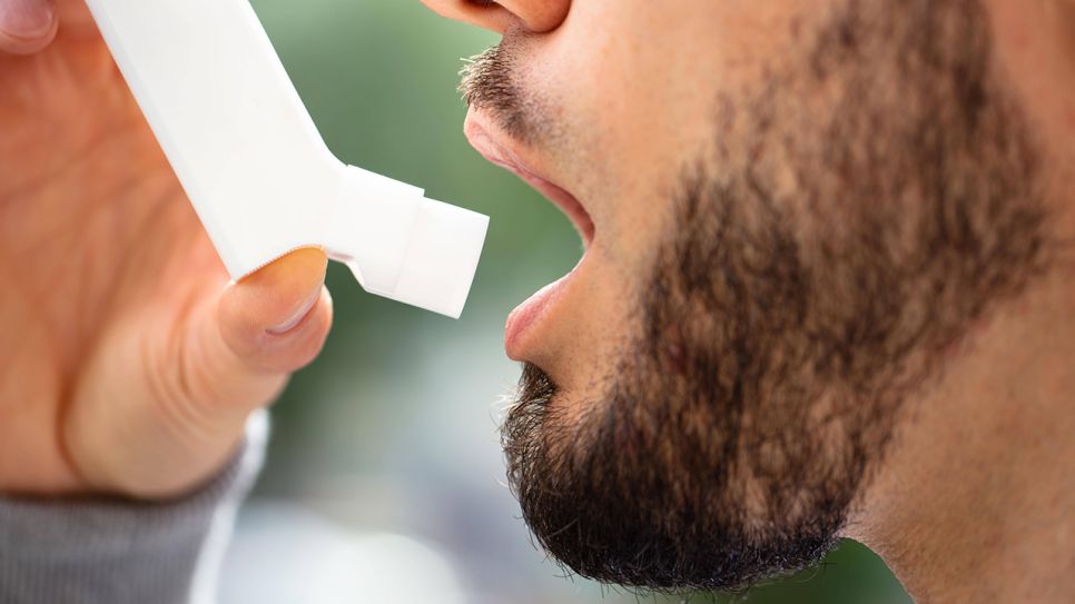 Mund und Hand eines Mannes mit Asthmaspray (Bild: imago images/Panthermedia)