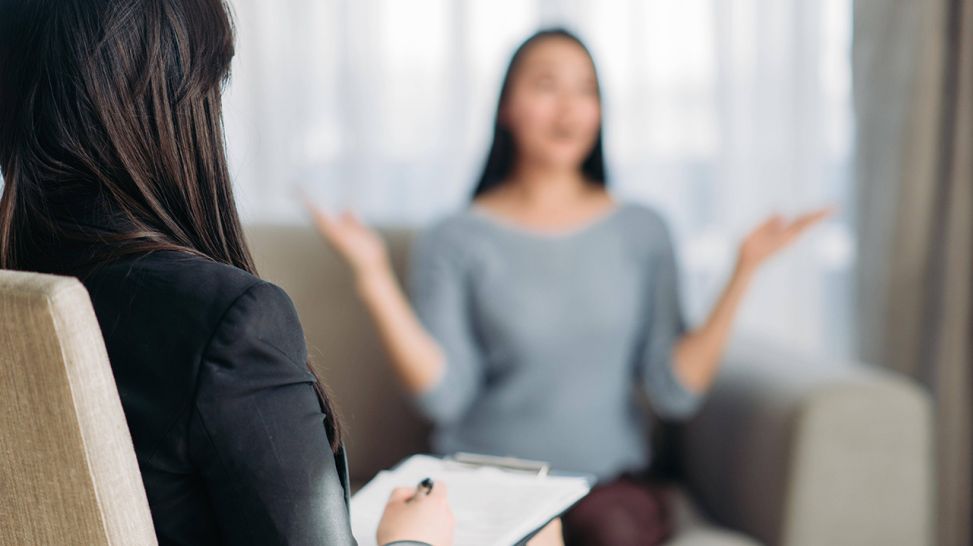 Psychotherapeutin hört Frau auch Sofa zu und macht Notizen (Bild: imago images/Panthermedia)