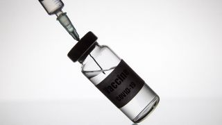 Spritze sticht in Kanüle mit SARS-CoV-2-Impfstoff (Bild: imago images/ ZUMA Wire)