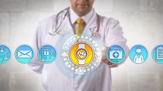 Arzt vor Digitalsymbolen zu Medizinn und Daten (Bild: imago images/agefotostock)