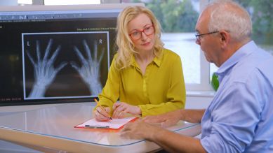 Ärztin berät Patient vor Röntgenbild zu Psoriasis-Arthritis (Bild: NDR)