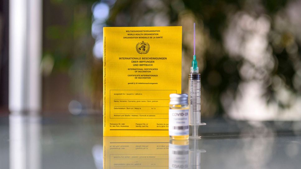 Impfpass mit Impfdosis und Spritze auf einem Tisch (Bild: imago images/Future Image)