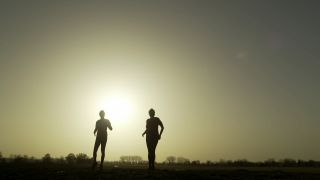 Zwei Menschen tanzen vor diesigem Himmel mit Sonne im Hintergrund (Bild: rbb)