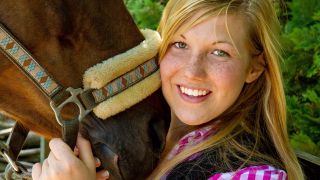 Junge Frau schmust mit Pferd (Quelle: imago/Panthermedia)