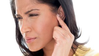 Frau hält sich das Ohr vor Schmerzen (Quelle: imago/Science Photo Library)