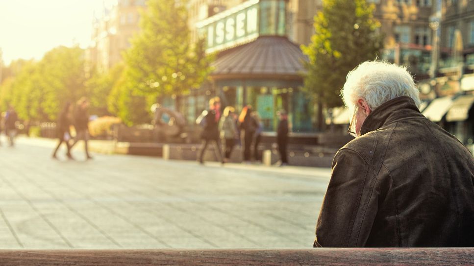 Älterer Mann sitzt in einer Stadt auf Bank (Bild: unsplash/Huy Phan)