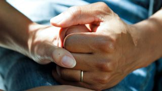 Hand eines Mannes mit Ehering hält Hand einer Frau (Bild: unsplash/National Cancer Institute)