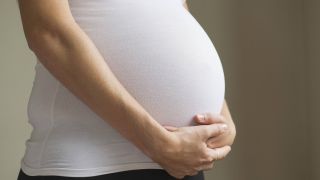 Schwangere Frau hält sich den Bauch (Quelle: imago/PhotoAlto)