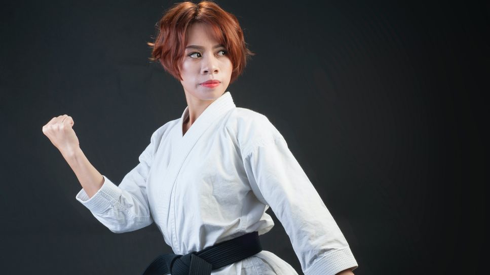 Frau im Karateanzug steht in Kampfstellung (Bild: unsplash/Thao Le Hoang)
