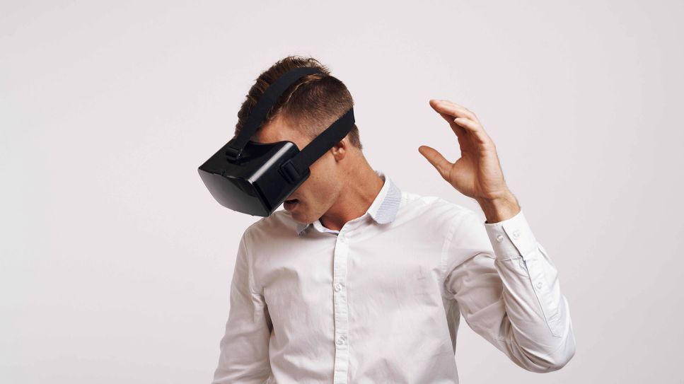 Mann mit VR-Brille greift nach oben (Bild: imago/YAY images)
