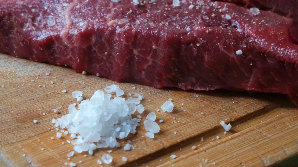 Salz im Essen: Häufchen Salz neben einem Steak (Bild: unsplash)