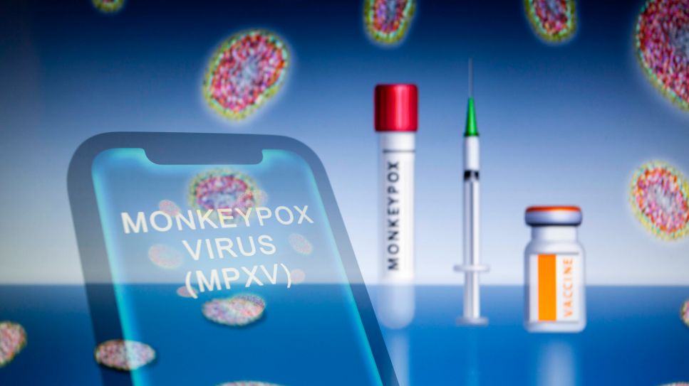 Illustration: Schrift Affenpocken auf Handy, im Hintergrund stehen Test- und Impf-Utensilien (Quelle: imago/ZUMA Wire)