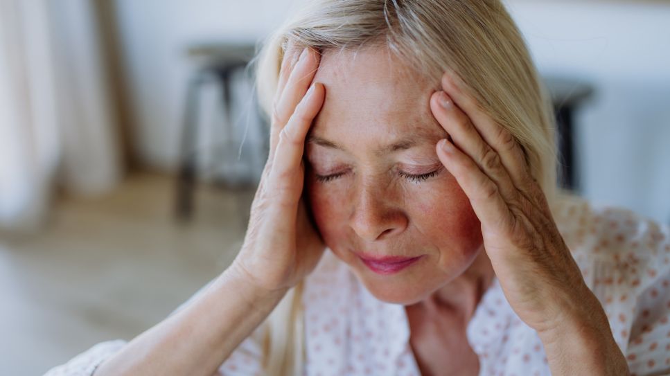 Ältere Frau hält sich den Kopf vor Schmerzen. Unerwartete Kopfschmerzen gehören zu den Hirntumor Symptomen (Quelle: Colourbox)