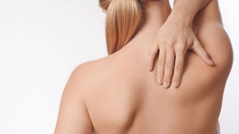 Rückenschmerzen: Frau hält sich den schmerzenden Nacken (Quelle: imago/Shotshop)