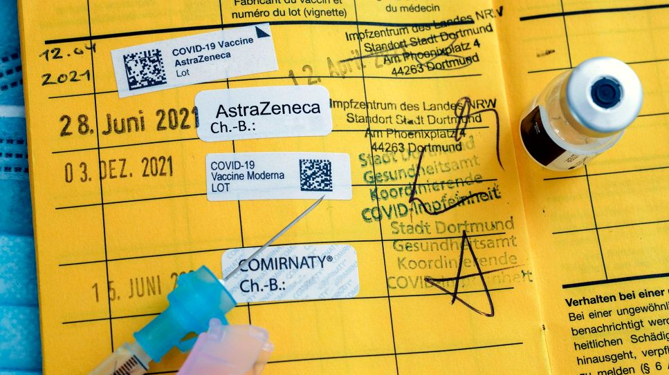 Angepasste Impfstoffe gegen Corona: Impfstoff und Spritze liegen auf einem Impfpass (Bild: imago/Friedrich Stark)