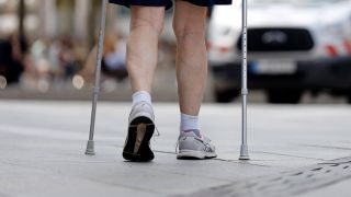Hilfe gegen Sturzgefahr: Beine und Gehstöcke eines Mannes auf der Straße (Bild: imago/Panthermedia)(Bild: imago/Future Image)