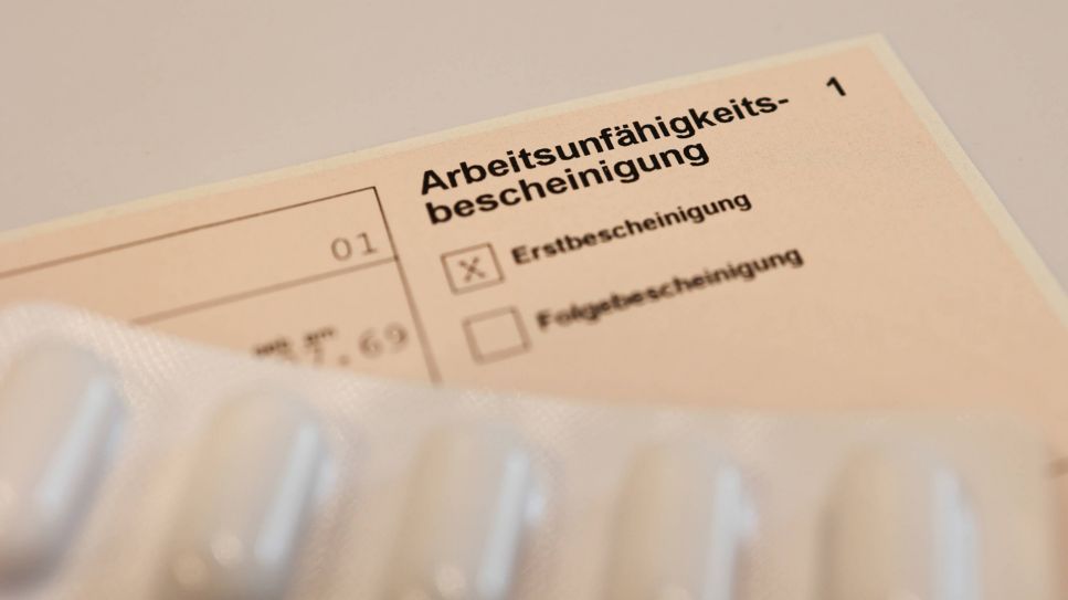 Krankschreibung, Bild zeigt: Krankschreibungszettel mit Tabletten (Quelle: imago/Lobeca)