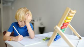 ADHS bei Kindern: Symbolbild zeigt verzweifeltes Kind über den Schulaufgaben (Quelle: Colourbox)