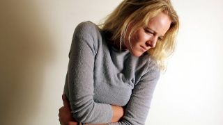 Stress löst Bauchkrämpfe aus, Bild zeigt Frau, die sich den schmerzenden Bauch hält (Quelle: imago images / HRSchulz)