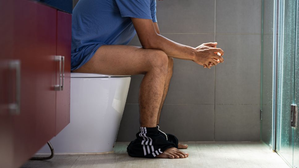 Blut im Urin: Bild zeigt Mann auf Toilette hinten im Bild sitzend (Quelle: Colourbox)