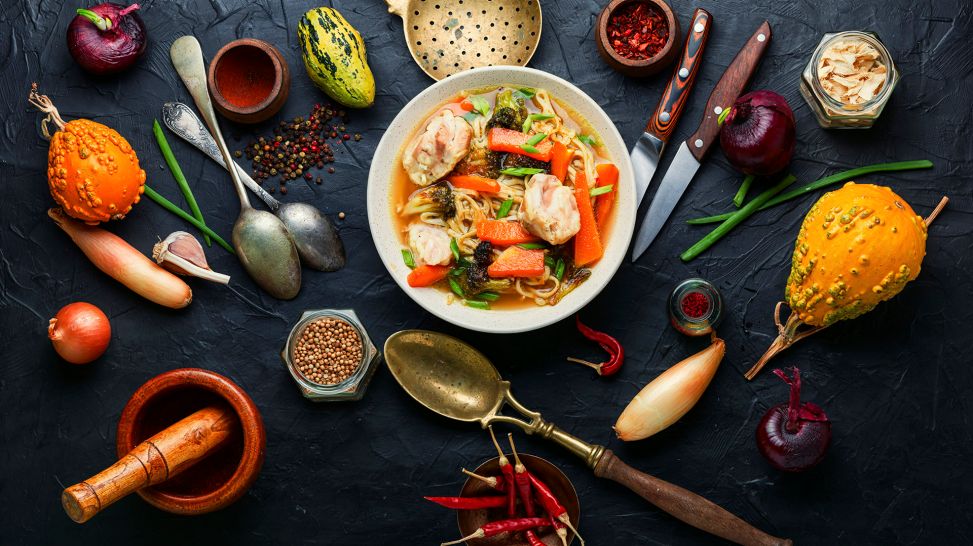 Ernährung nach Darm-OP: Bild zeigt Bowl mit Gemüse und Fisch umgeben von Gemüse und Gewürzen auf Tisch (Bild: Colourbox)