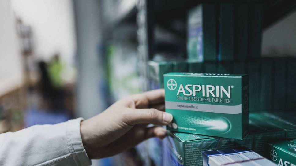 Aspirin, Bild zeigt Apotheker, der eine Schachtel Aspirin in den Schrank stellt (Quelle: imago images / photothek)