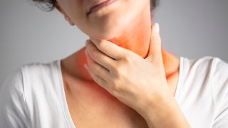 Scharlach: Bild zeigt Frau, die sich an schmerzenden Hals fasst (Bild: Colourbox)