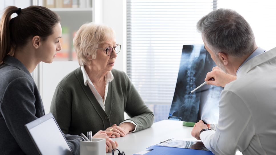 Osteoporose, Bild zeigt Arzt, der einer Patientin und ihrer Tochter an einem Model Osteoporose erklaert (Quelle: Colourbox)
