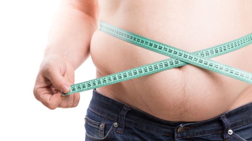 Adipositas, Bild zeigt übergewichtigen Mann, der ein Maßband um den Bauchumfang hält (Quelle: Colourbox)