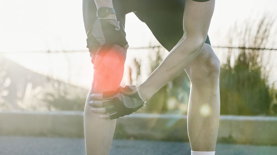 Gelenkschmerzen: Bild zeigt Mann auf Straße, der sich an schmerzendes Knie fast (Bild: Colourbox)