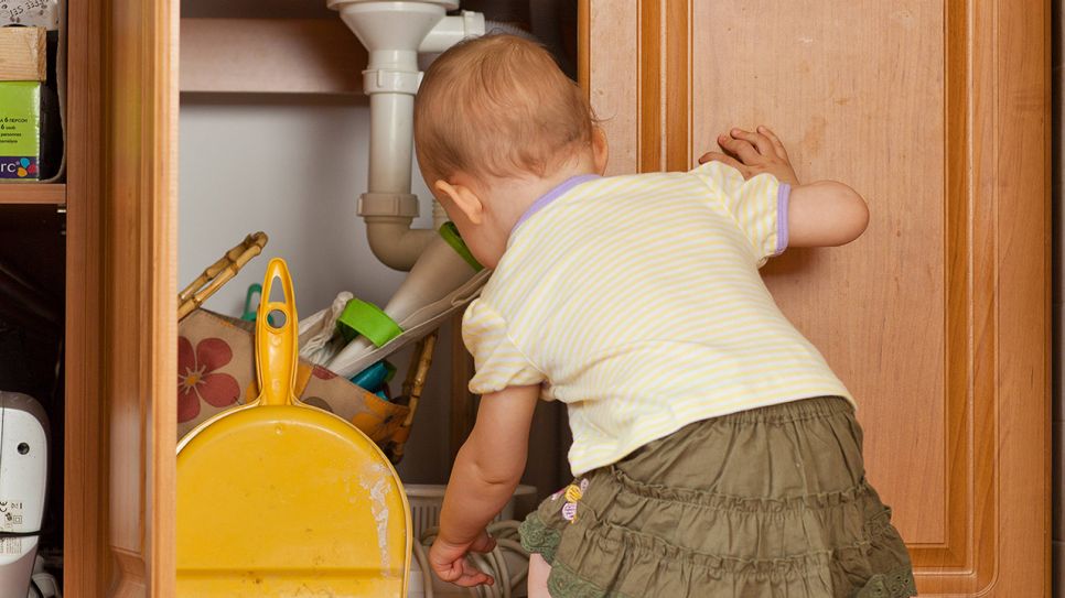 Kleinkind greift in einen Putzschrank unter Spüle (Bild: imago/BE&W)