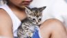 Katze sitzt auf dem Schoß eines Jungen (Quelle: imago/Westend61)
