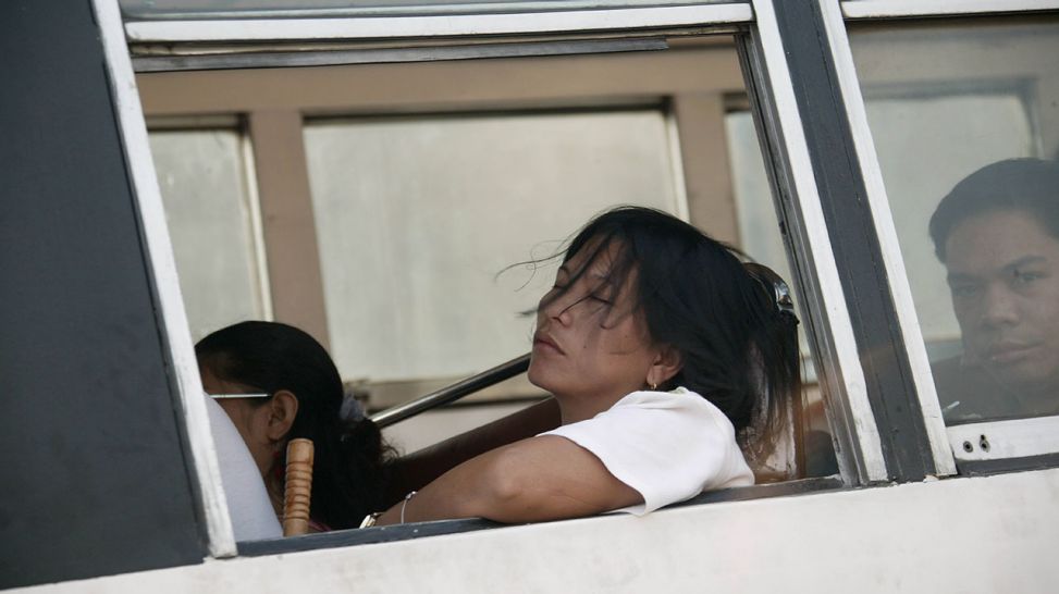 Eine Filipina im Bus mit geschlossenen Augen (Quelle: imago/Hans Blossey)