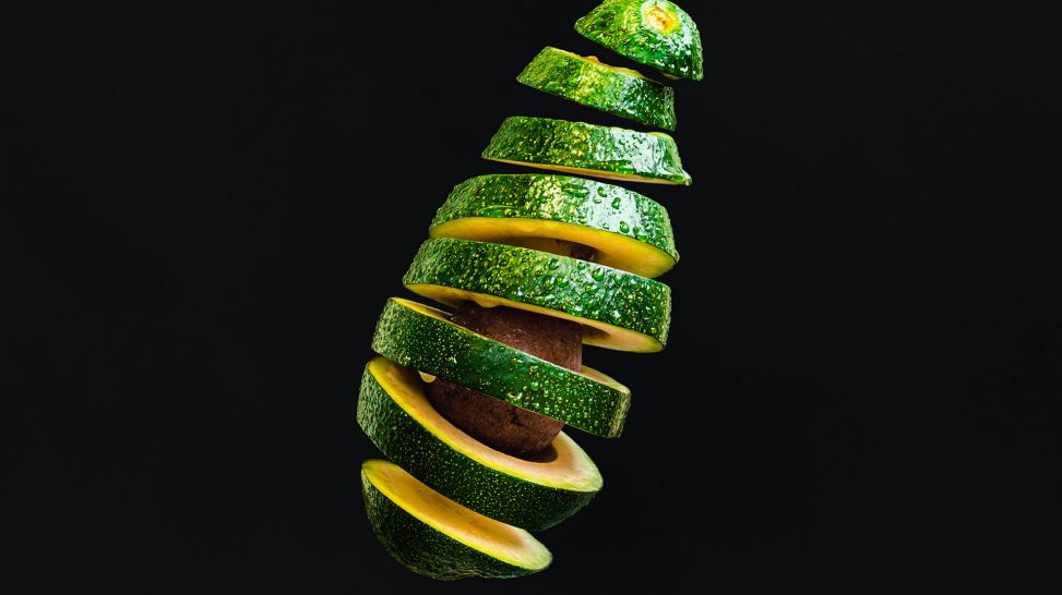 Cholesterin senken: Avocado zerschnitten vor Schwarz (Bild: unsplash/Olga Zhushman)