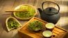 Cholesterin senken: Grüner Tee in Blättern und aufgegossen in Kanne auf einem Tisch (Bild: unsplash/Tang Don)