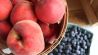Cholesterin senken: Äpfel und Heidelbeeren in Körben auf Tisch (Bild: unsplash/Taya Dianna)