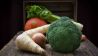 Brokkoli, Sellerie, Kürbis und andere Gemüse vor einer Holzkiste auf Holztisch (Bild: imago images/Westend61)