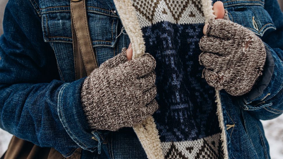 Mann mit Handschuhen zieht Jacke dichter über Winterpullover (Quelle: Colourbox)
