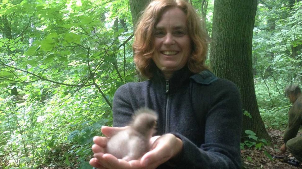 Die Autorin Maren Schibilsky hält ein Schreiadlerbaby in der Hand; Quelle: rbb/Christian Schulz