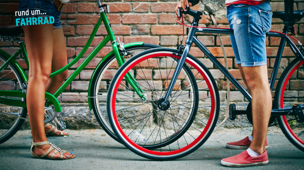 Zwei Personen halten jeweils ein buntes Fahrrad, Logo "rund um... Fahrrad" (Quelle: colourbox.com/rbb)