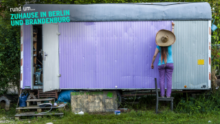 Eine Frau streicht einen Bauwagen lila, Logo "rund um... Zuhause in Berlin und Brandenburg" (Quelle: rbb/imago images/Westend61)