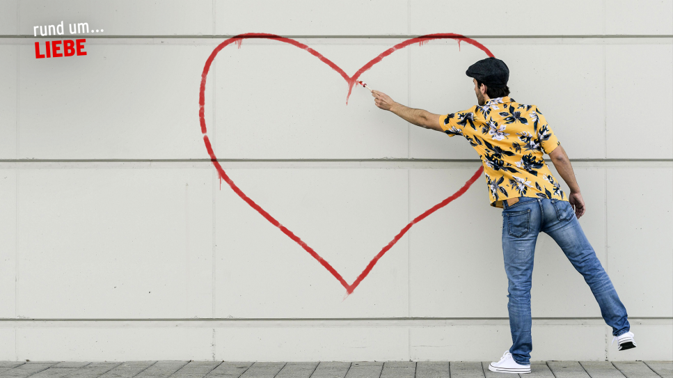 Mann malt ein Herz an eine Wand; Logo "rund um... Liebe" (Quelle: rbb/imago images/Westend61)