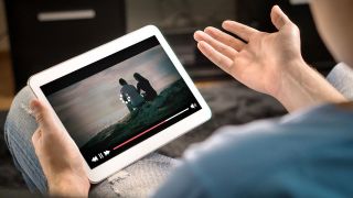 Ein Mann hält ein Tablet in der Hand, auf dem ein Video zu sehen ist, dass nicht lädt (Quelle: Colourbox)