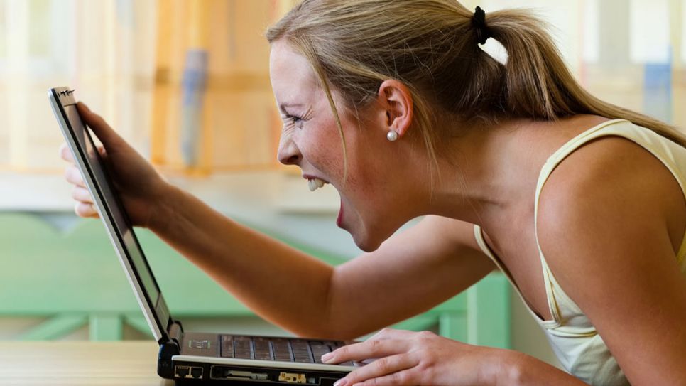 Eine Frau schreit einen Laptop an (Quelle: Colourbox)